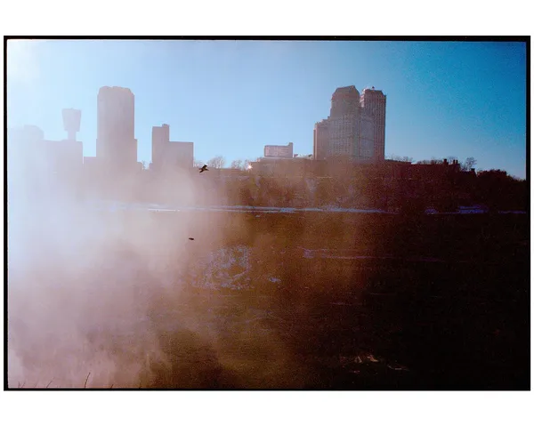 A city skyline partially obscured by mist at Niagara Falls.