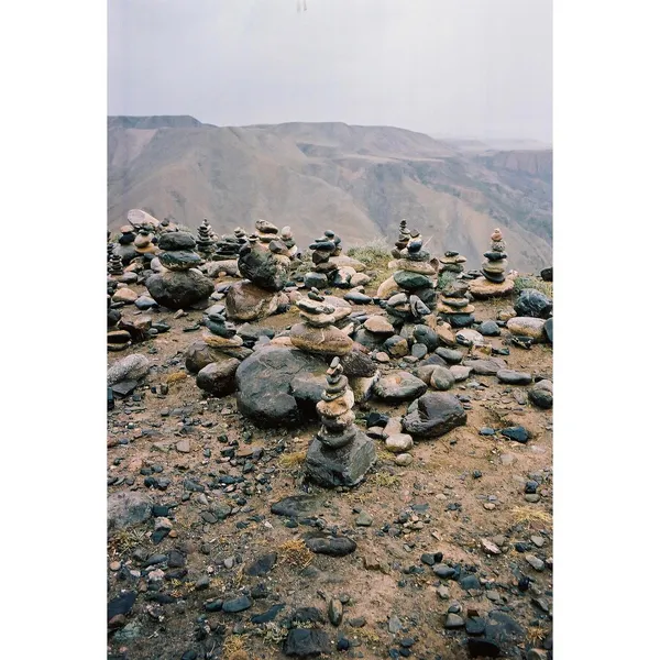 A vertical view of rock cairns on a high, barren landscape.