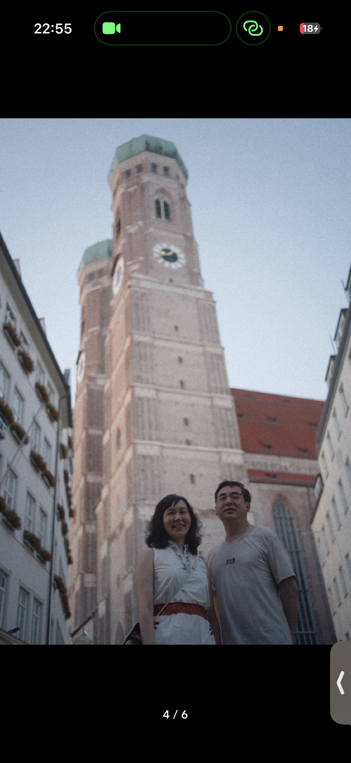 Two people in front of church towers.